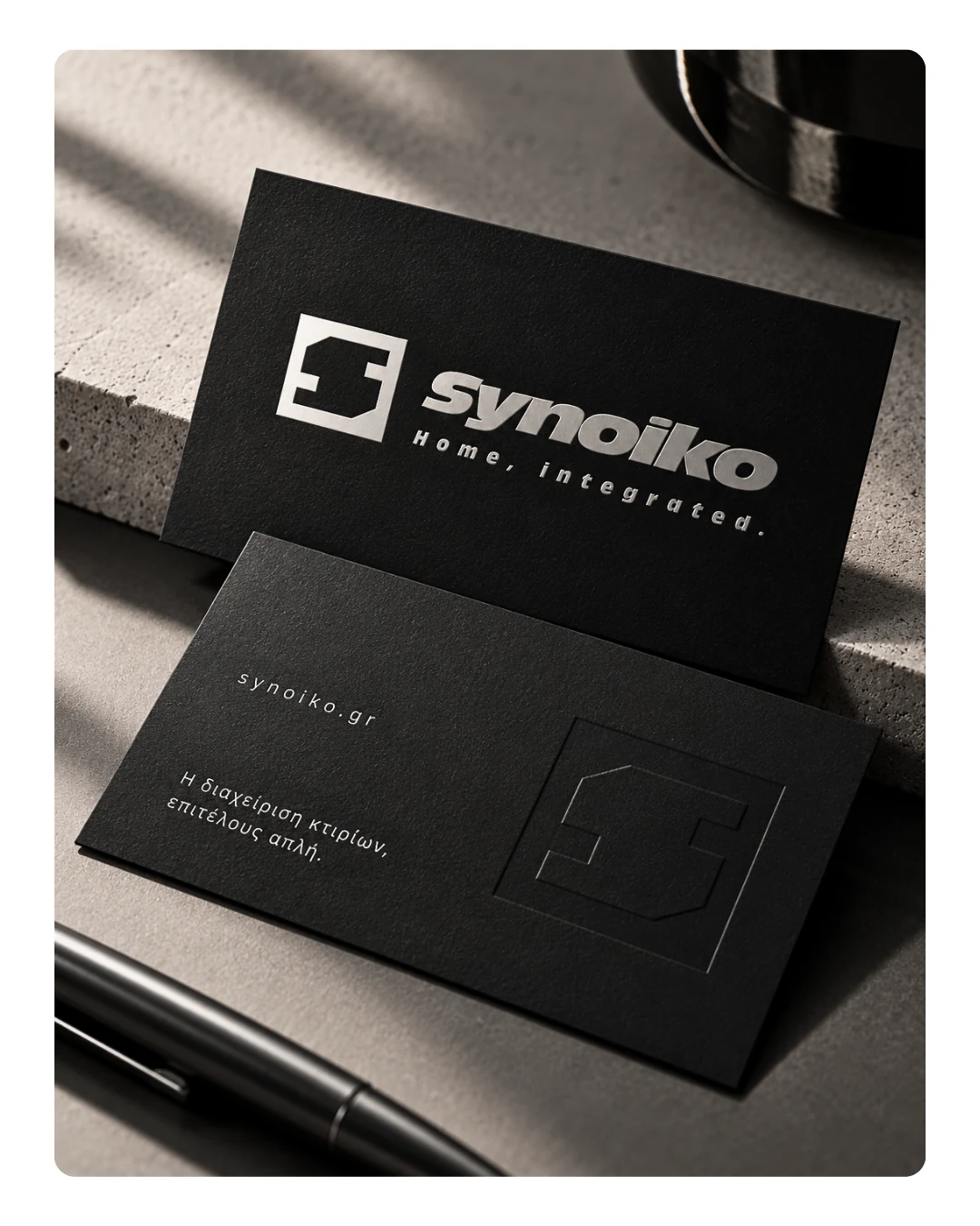 Synoiko brand identity on black business-card mockups